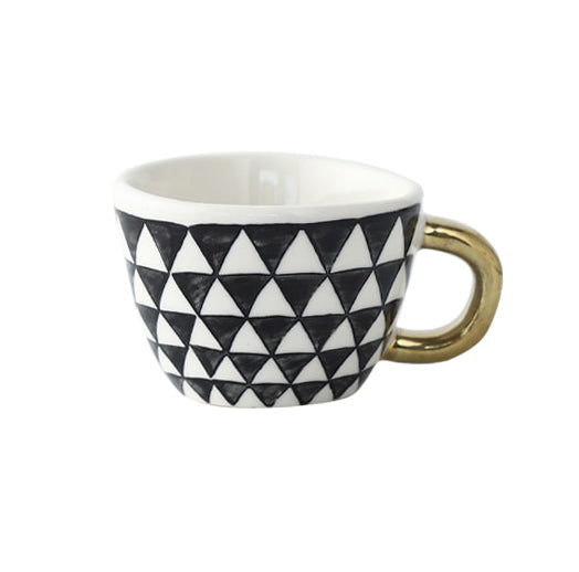 Mugg med abstrakt geometriskt mönster och guldhandtag
