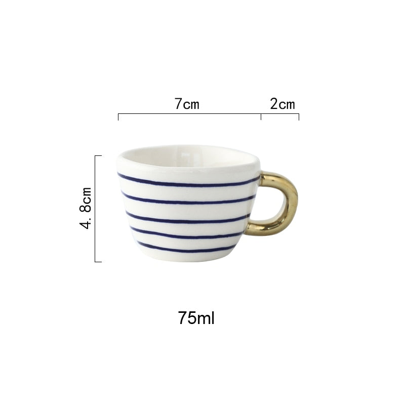 Mugg med abstrakt geometriskt mönster och guldhandtag