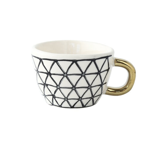 Mugg med abstrakt geometriskt mönster och guldhandtag