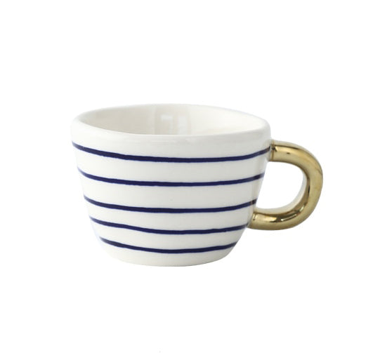 Mugg med abstrakt geometriskt mönster och guldhandtag